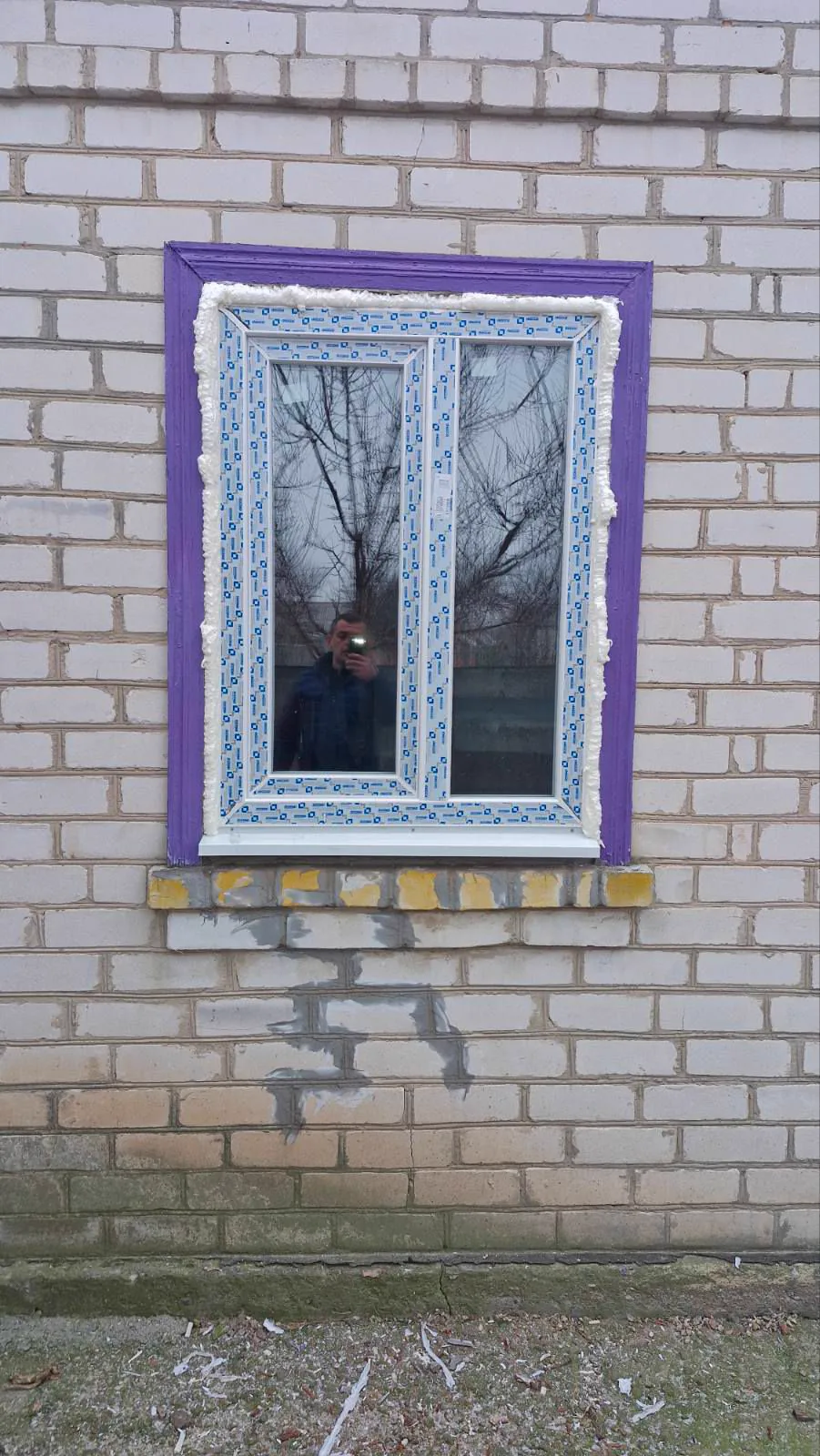 Біле вікно на цегляному фасаді